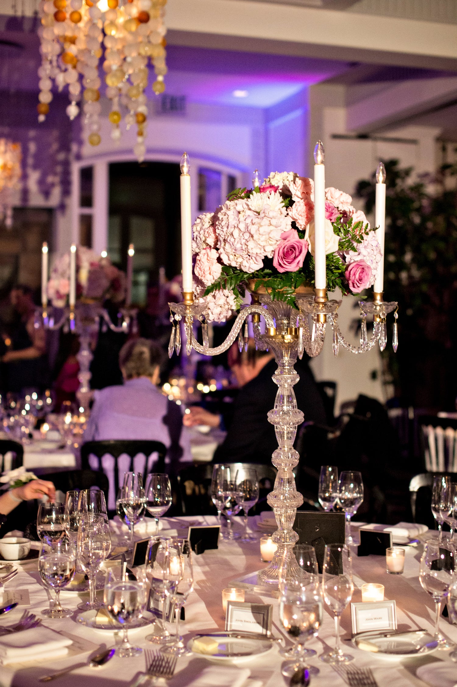 Tall wedding reception candelabra centerpiece with hydrangeas and roses, styled for an elegant formal table setting