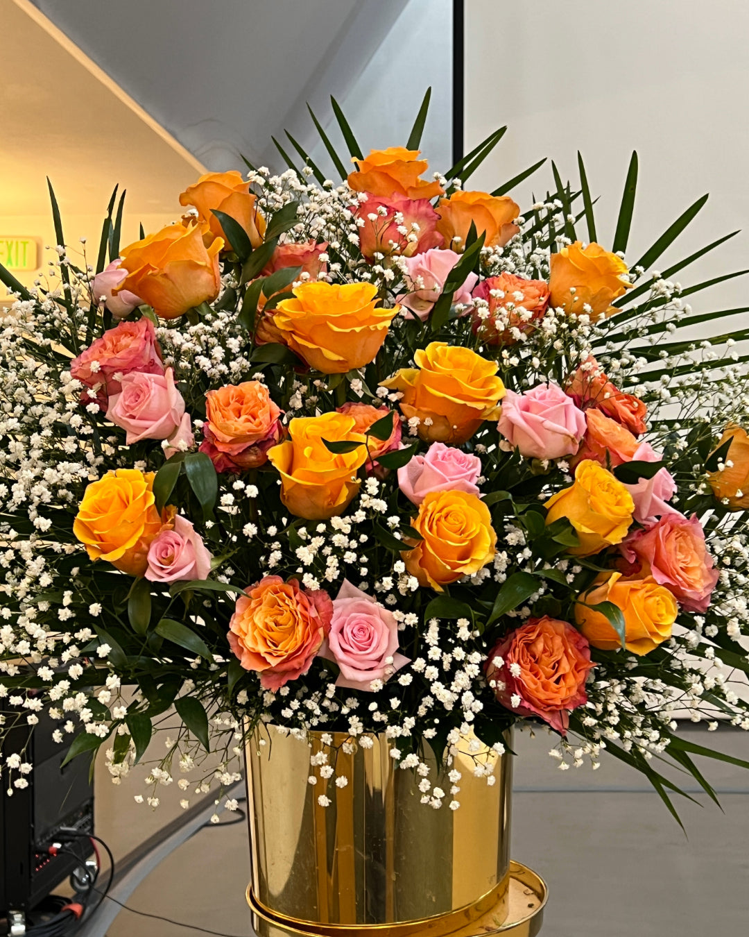 Elegant memorial floral arrangement with peach and pink roses and baby’s breath – Los Angeles funeral florist