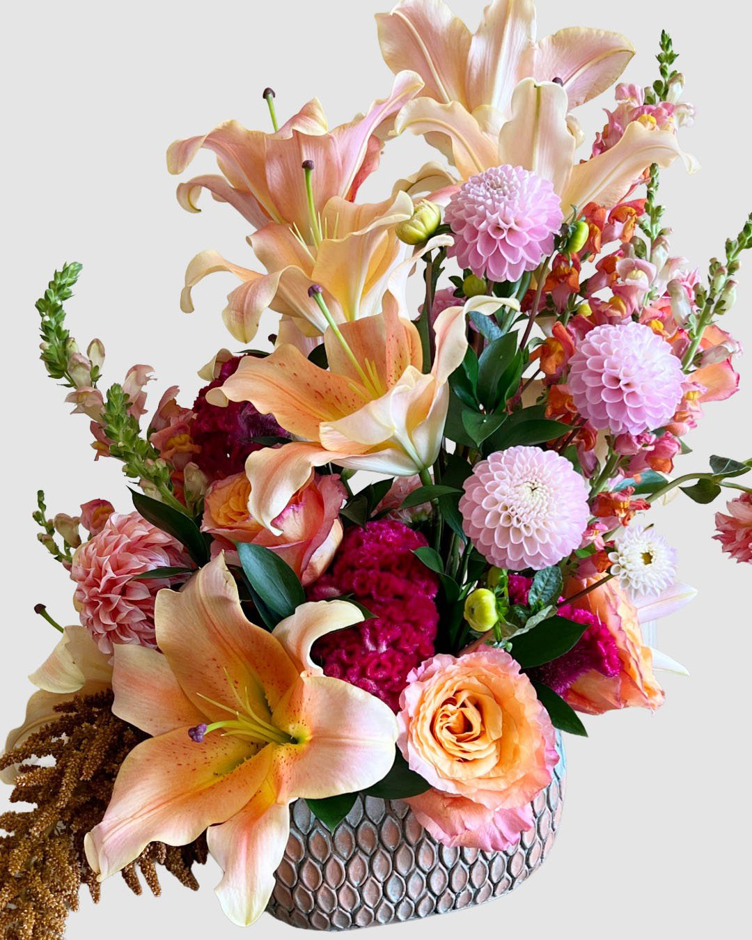 Romantic arrangement with lilies, dahlias, and roses in soft pink and coral tones, for anniversary flower gifting.