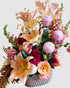 Romantic arrangement with lilies, dahlias, and roses in soft pink and coral tones, for anniversary flower gifting.