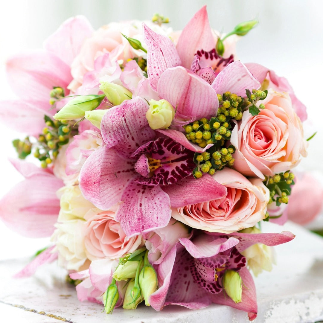 A close-up of a floral bouquet featuring roses and orchids to represent the grand wedding floral package.