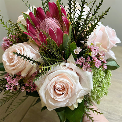 Intimate wedding bouquet with protea, blush roses, and pink waxflower by Pearson Floral Designs in Los Angeles.