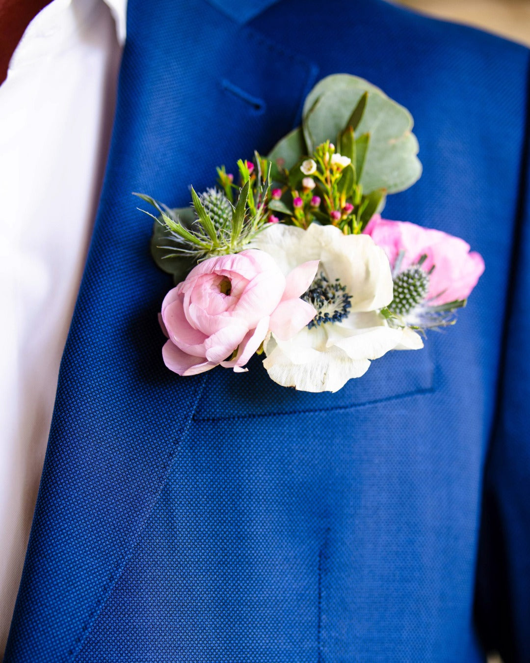Modern floral pocket square boutonniere on a blue suit jacket
