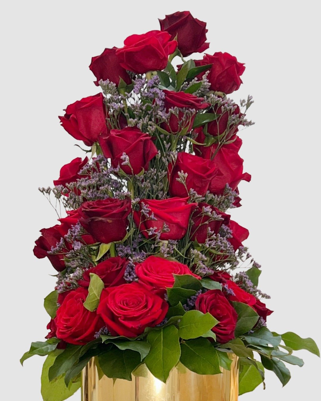 Red Rose Tower arrangement with layered red roses, limonium, and greenery in a gold vase.