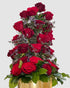 Red Rose Tower arrangement with layered red roses, limonium, and greenery in a gold vase.
