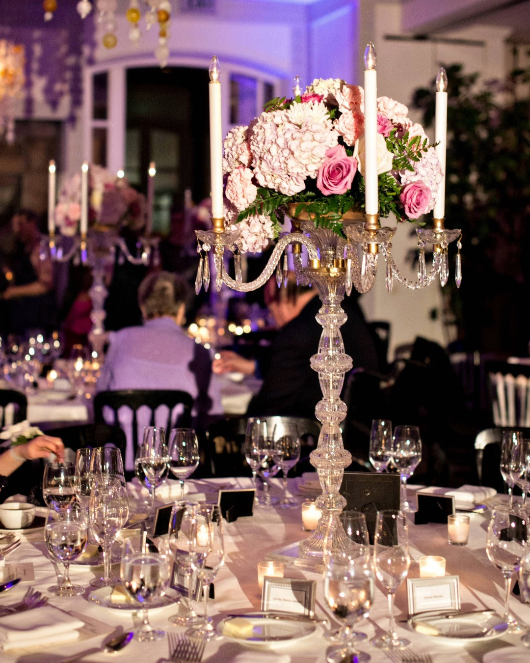 Wedding reception florals featuring a crystal candelabra with lavender and pink florals and candles.