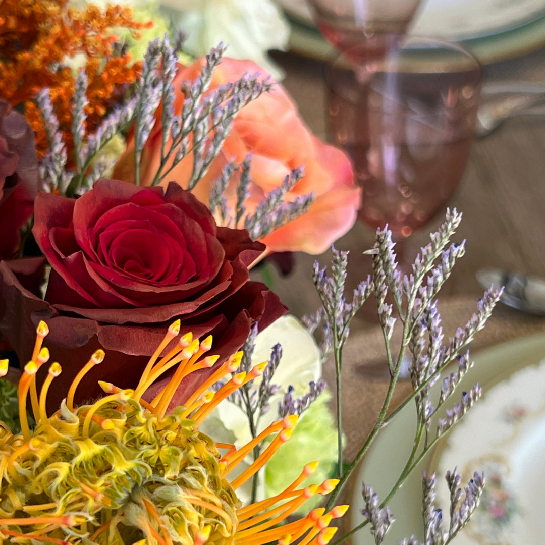 Thanksgiving centerpiece with hydrangeas, roses, orange pincushion protea, and Limonium